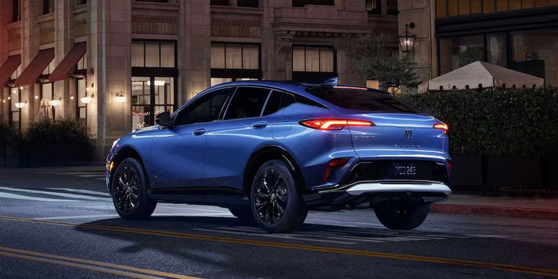 Blue 2026 Buick Envista driving through a city street at night